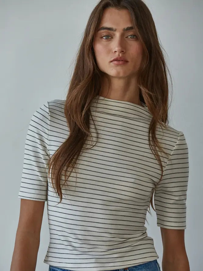Woman wearing a striped shirt against a plain background