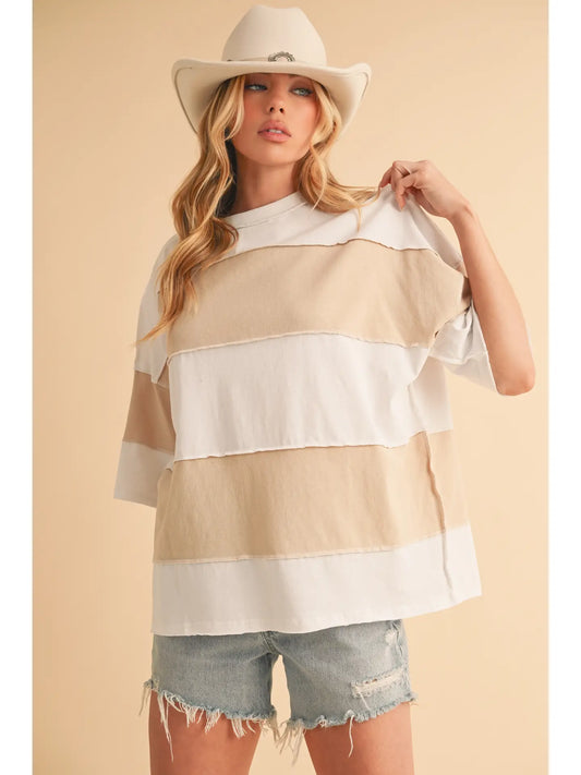 Woman wearing a striped shirt and cowboy hat against a beige background