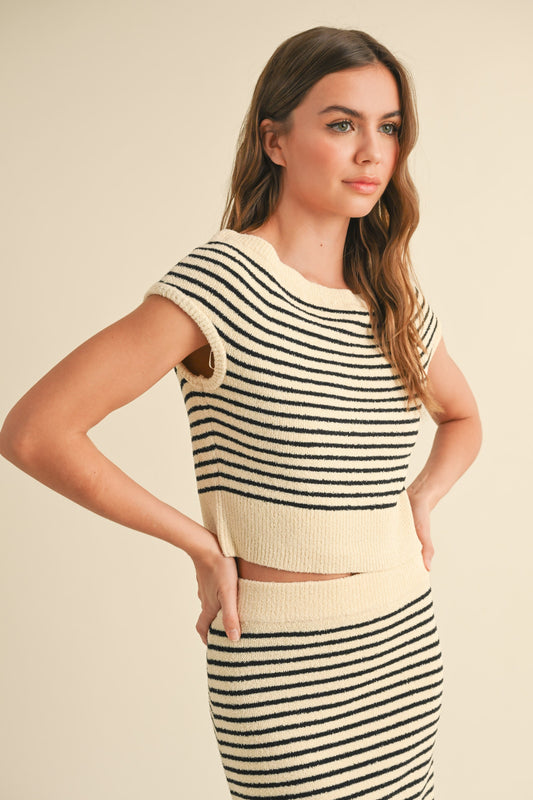 Woman wearing a striped top and skirt set against a beige background